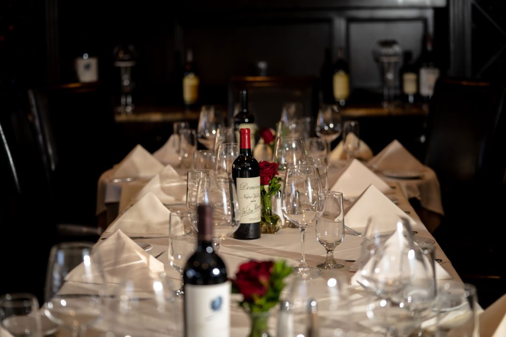Banquet table set up in the Boccaccio's private wine room with bottles of wine and wine glasses arranged beautifully