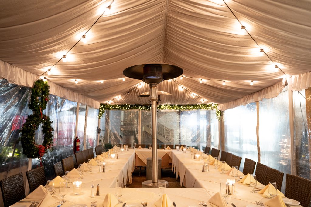 A holiday private party booking the back of Boccaccio's tent, featuring a banquet table with a lamp heater in the middle